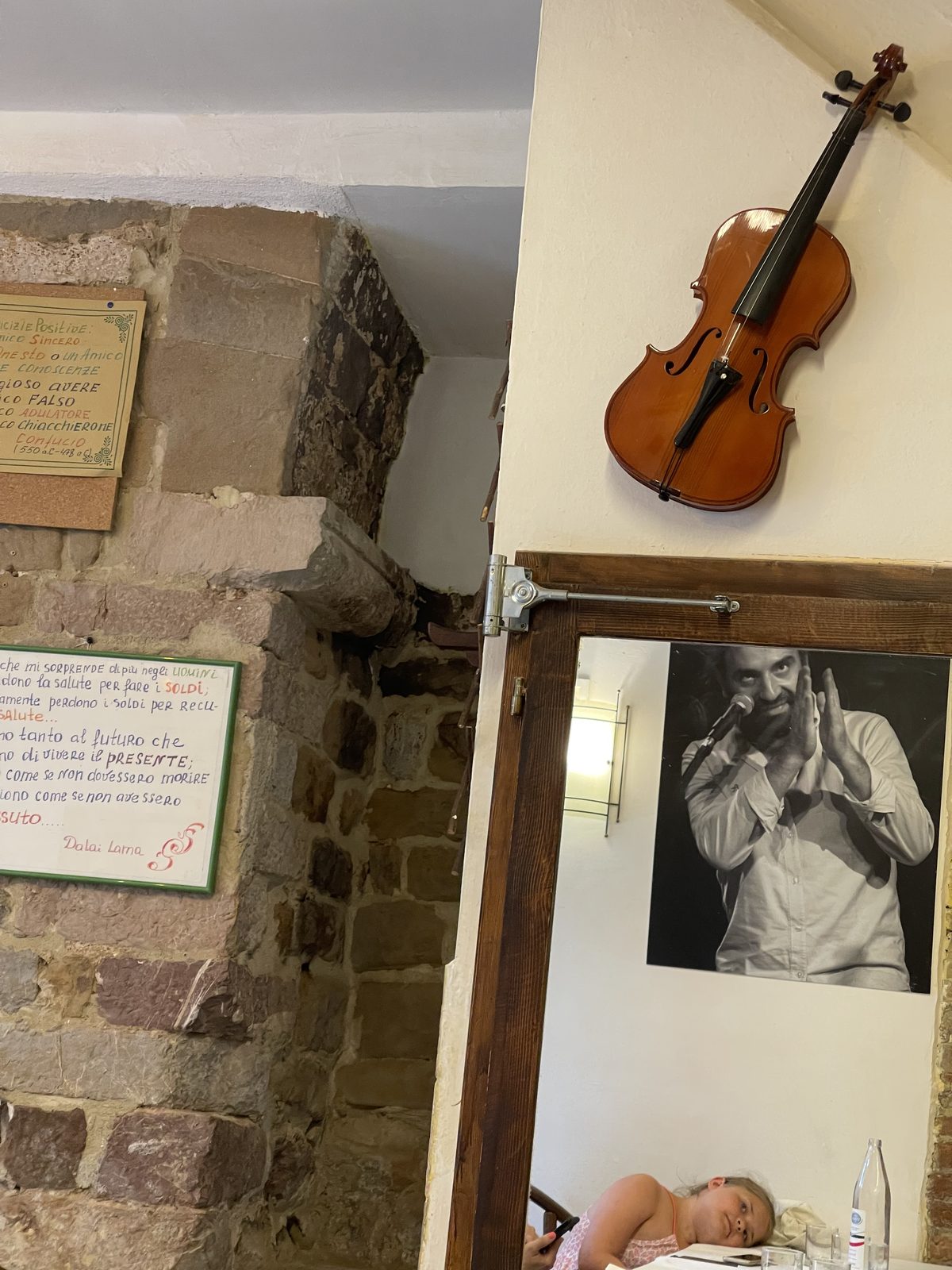 Dettaglio di una trattoria a Perugia con violino e frasi alle pareti