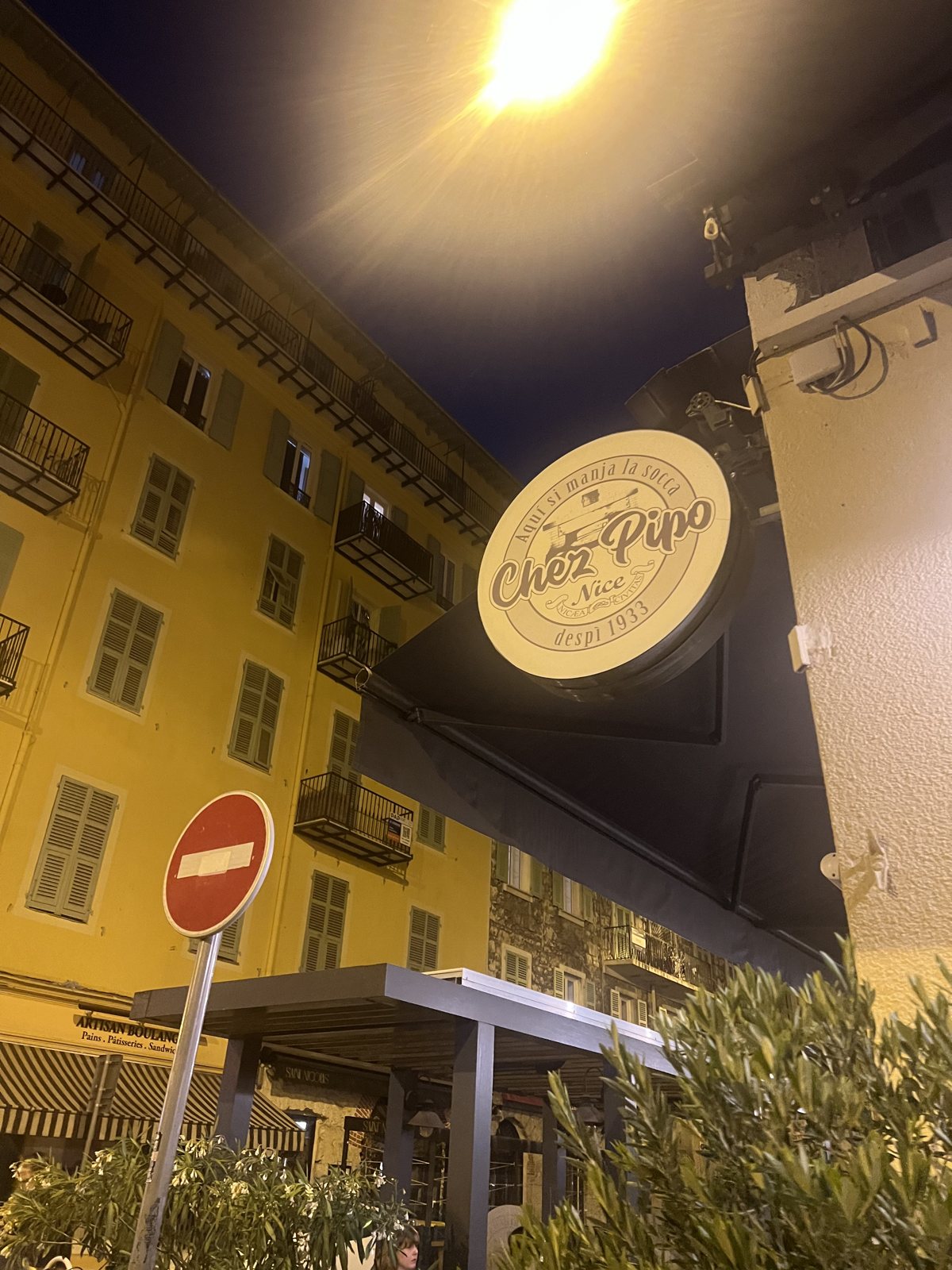 L'insegna illuminata di Chez Pipo, il locale della socca vicino al porto di Nizza