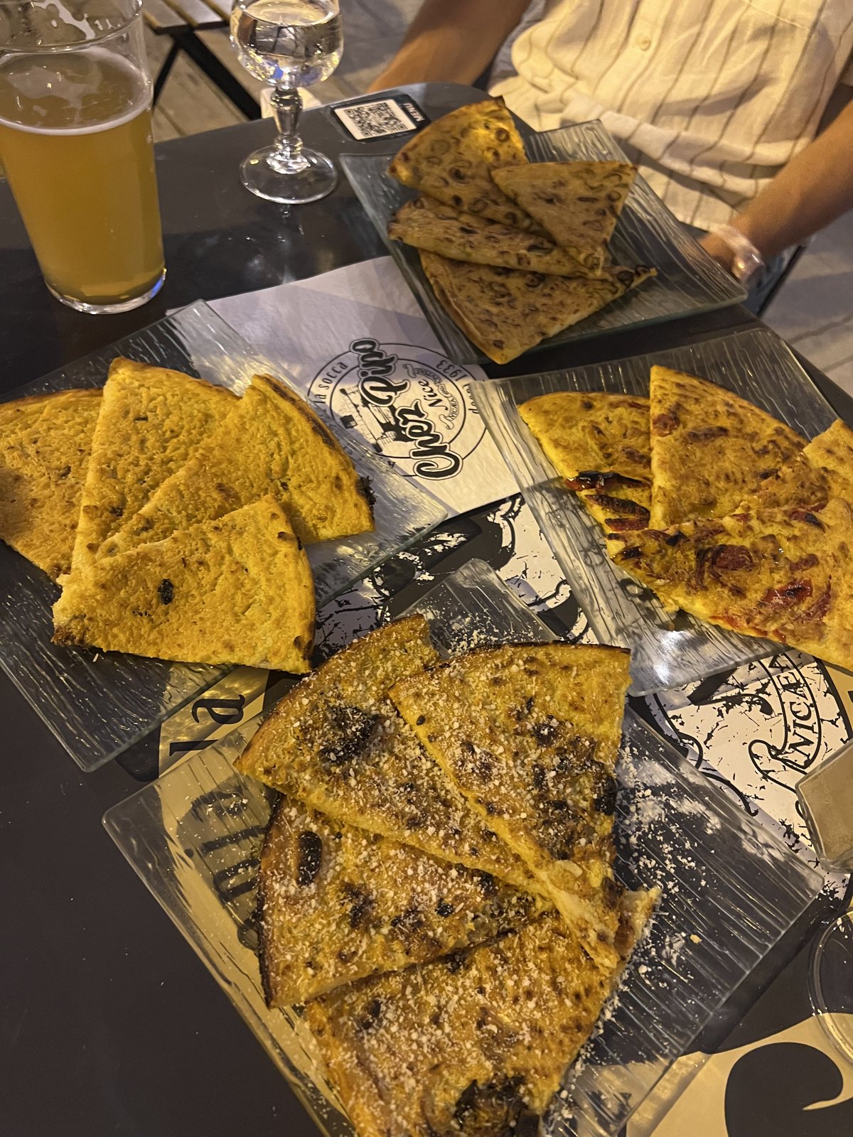 Socca e pissaladière servite sul vassoio da Chez Pipo, vicino al porto di Nizza
