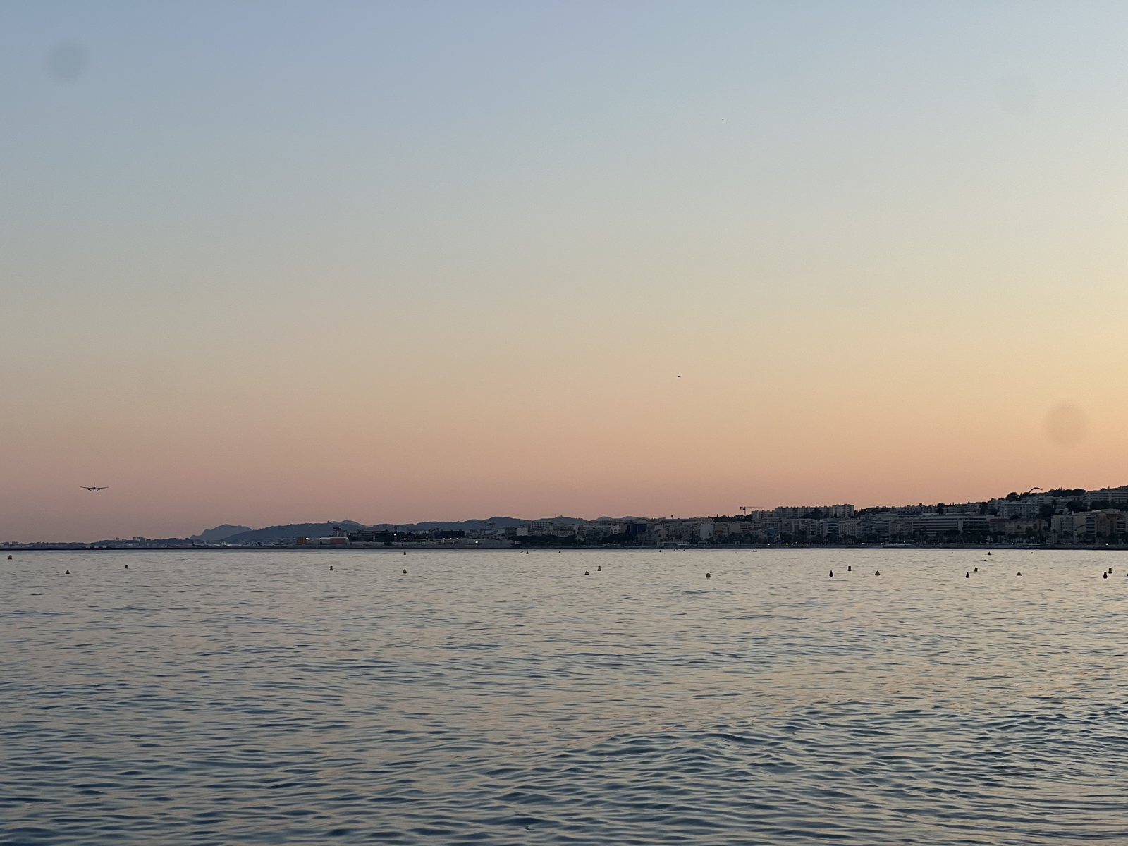 Il tramonto sulla Baie des Anges a Nizza, con il cielo rosa e arancione sul mare